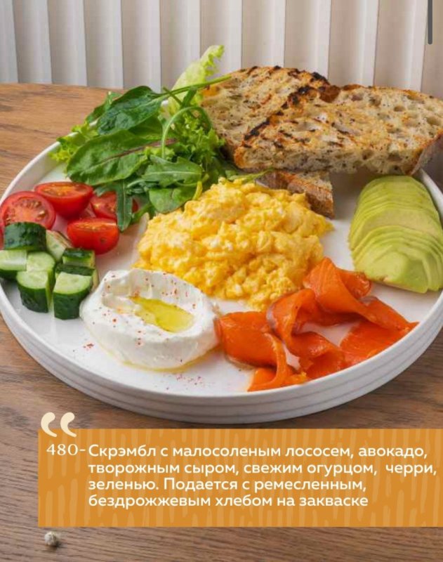 Скрэмбл с малосоленым лососем, авокадо, творожным сыром, свежим огурцом, черри, зеленью. Подается с ремесленным, бездрожжевым хлебом на закваске